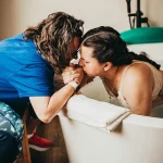Lubbock birth photographer session of water birth at local birthing center